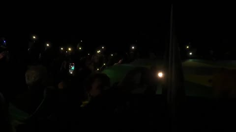 Manifestação unida rezando perante a bandeira em frente ao Quartel do Exército
