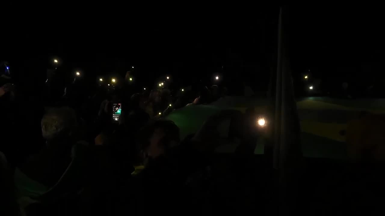 Manifestação unida rezando perante a bandeira em frente ao Quartel do Exército