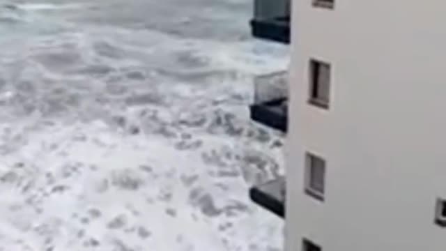 Waves cover the balconies of a Spanish hotel