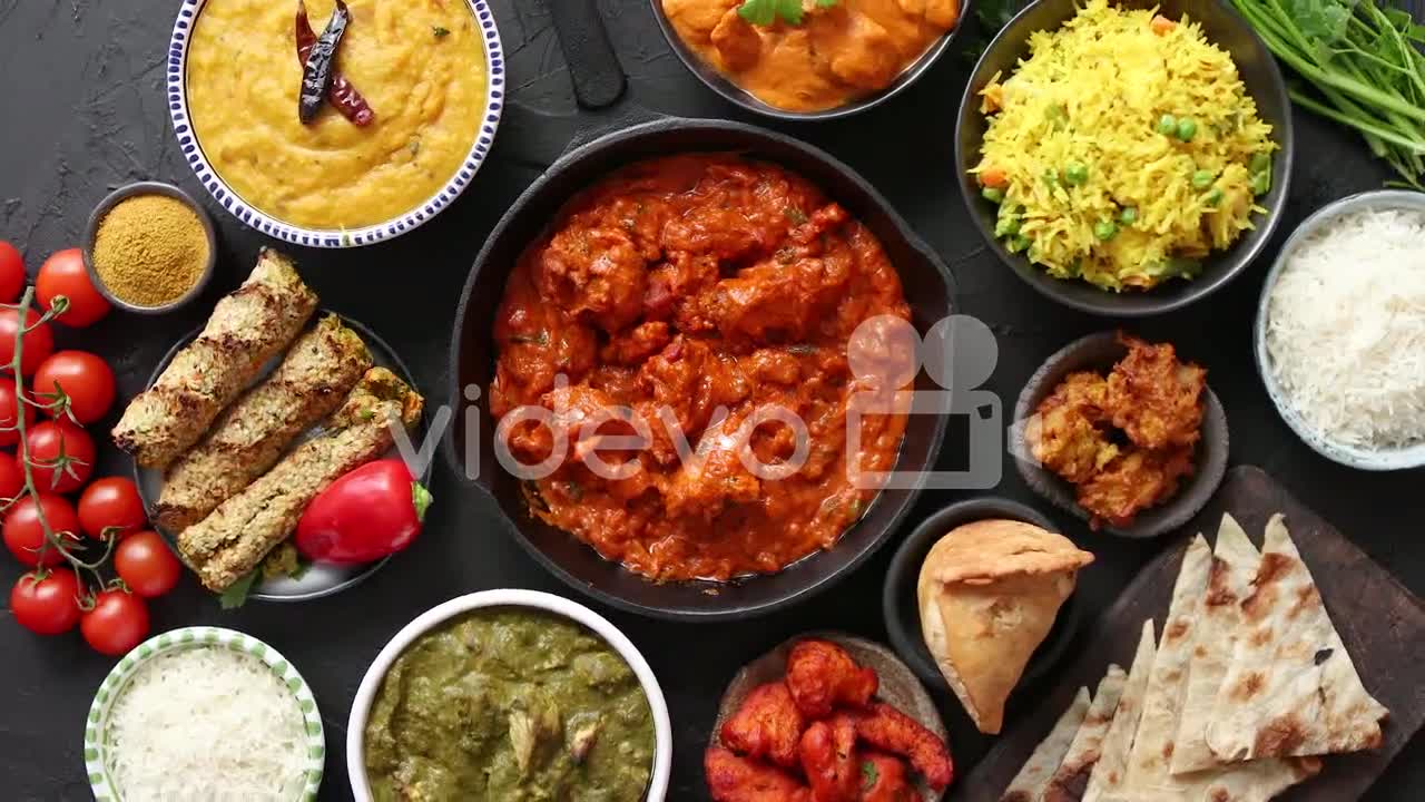 Assortment of various kinds of Indian cousine on dark rusty table