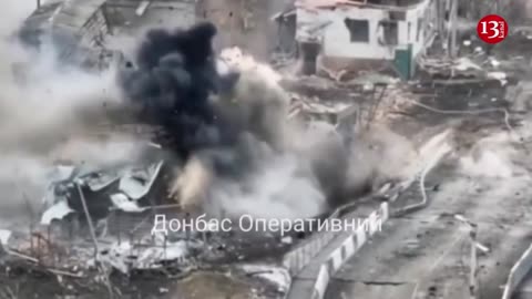 Ukrainian soldiers display destroyed vehicles along the road in Bakhmut