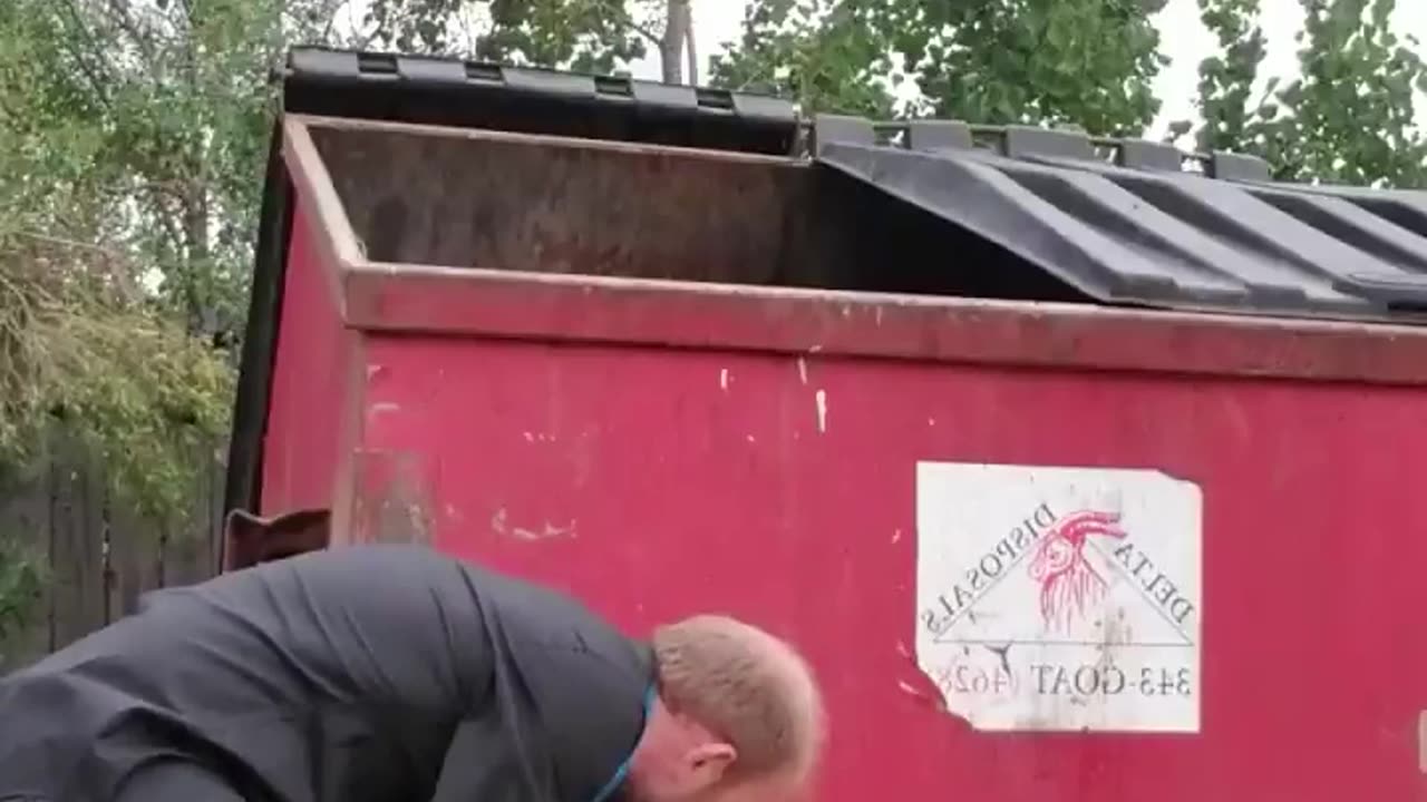 Man Helps Raccoon Stuck Under Dumpster