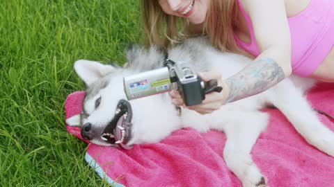 A Woman Recording a Video While Petting Her Dog