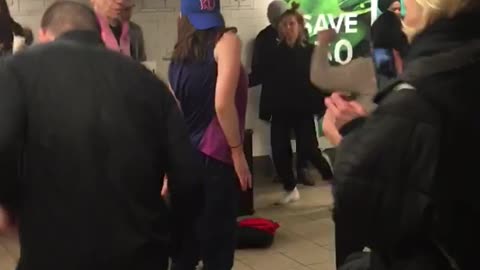 Several people have dance party in subway station