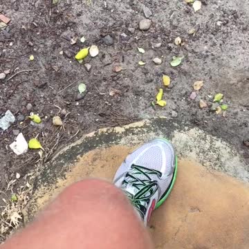 Man in black wet suit throwing punches at air at beach