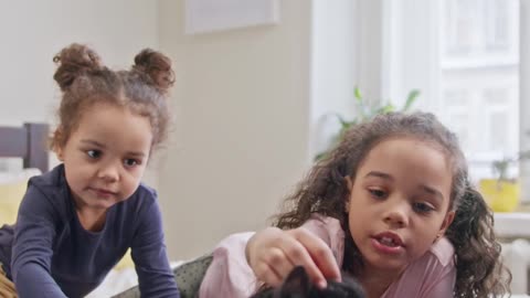 Kids Petting their Cat On the bed