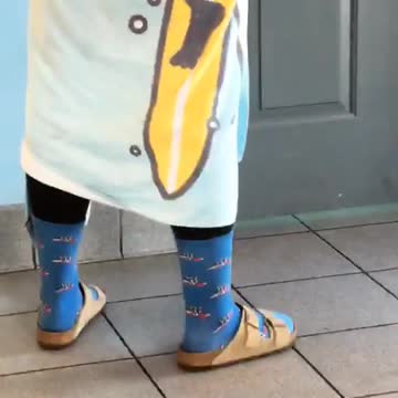Guy waiting for public restroom in wetsuit and blue towel