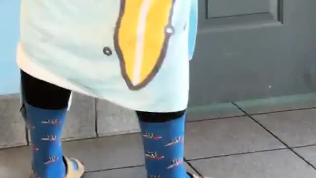 Guy waiting for public restroom in wetsuit and blue towel