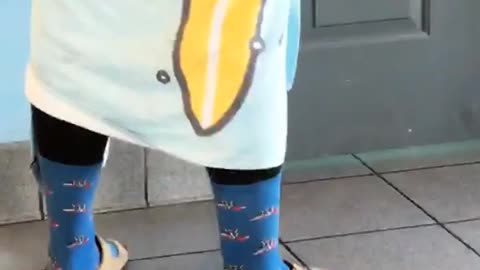 Guy waiting for public restroom in wetsuit and blue towel