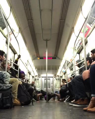 Man in purple hat performs on subway