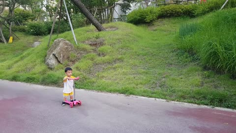 a kid riding a kickboard