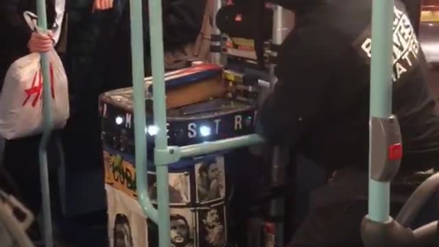 Guy with black lives matter jacket with blinking lights glowing cart in subway