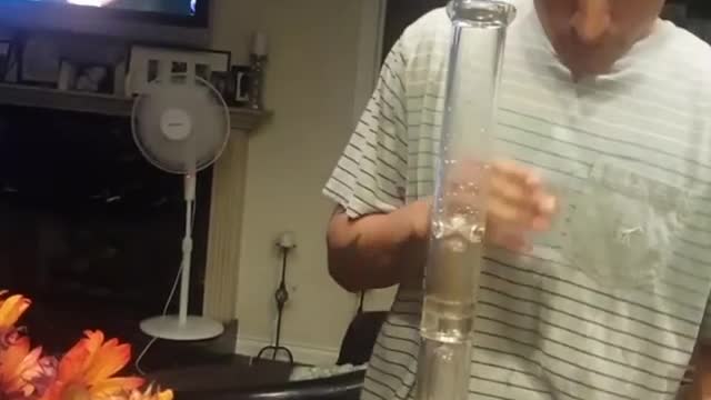 Nsfw guy striped shirt takes a hit from bong then takes a shot and spits it out