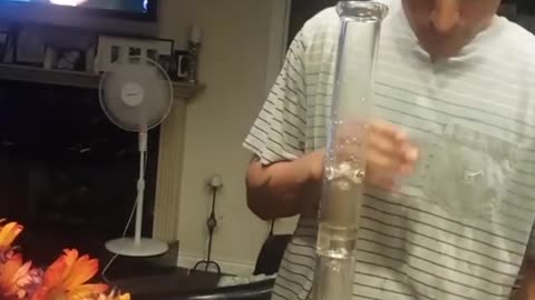 Nsfw guy striped shirt takes a hit from bong then takes a shot and spits it out