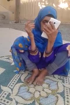 An old lady watched some thing o phone and smile at the end look gorgeous