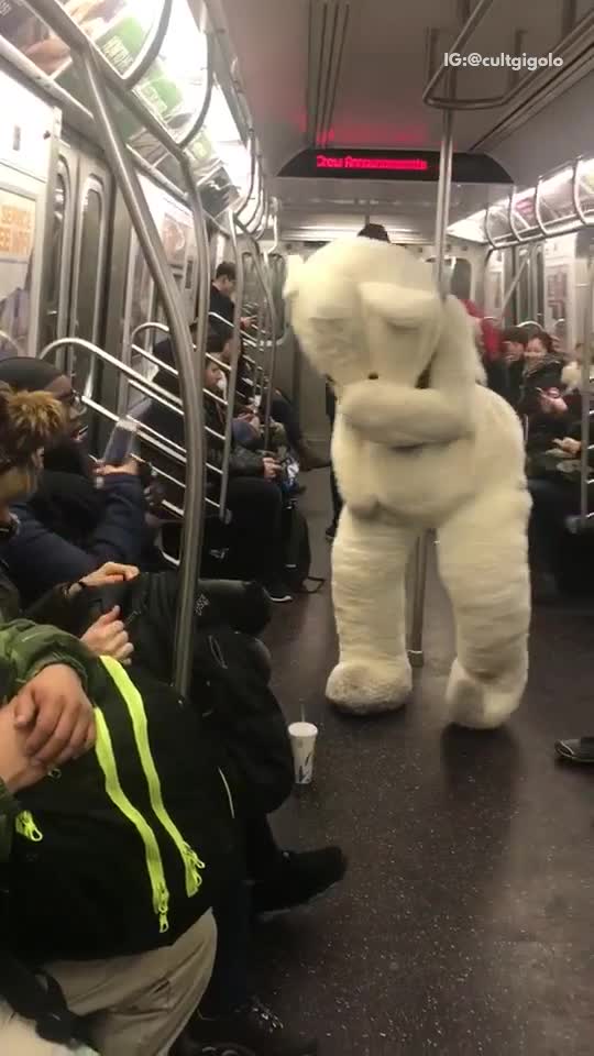 Person in large white bear costume on subway