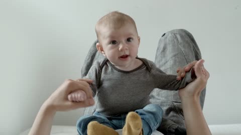 Cute Baby on belly of his mother plays and smiles