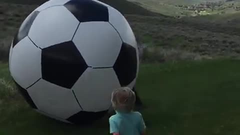 Dad kicks huge soccer ball and knocks baby out!