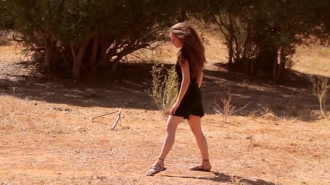 Attractive girl wearing black dress dancing in the nature. Free stock footage