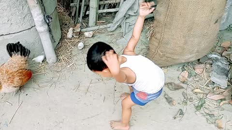 The little girl trying to catch some chicken child. Can she catch it? Watch the video.