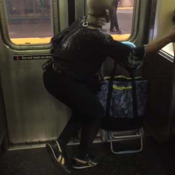 Blonde woman dancing next to subway train door