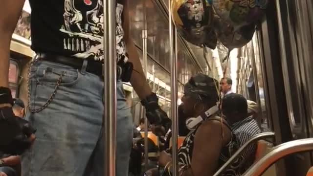 Guy dancing fighting moves subway door blue hat black shirt