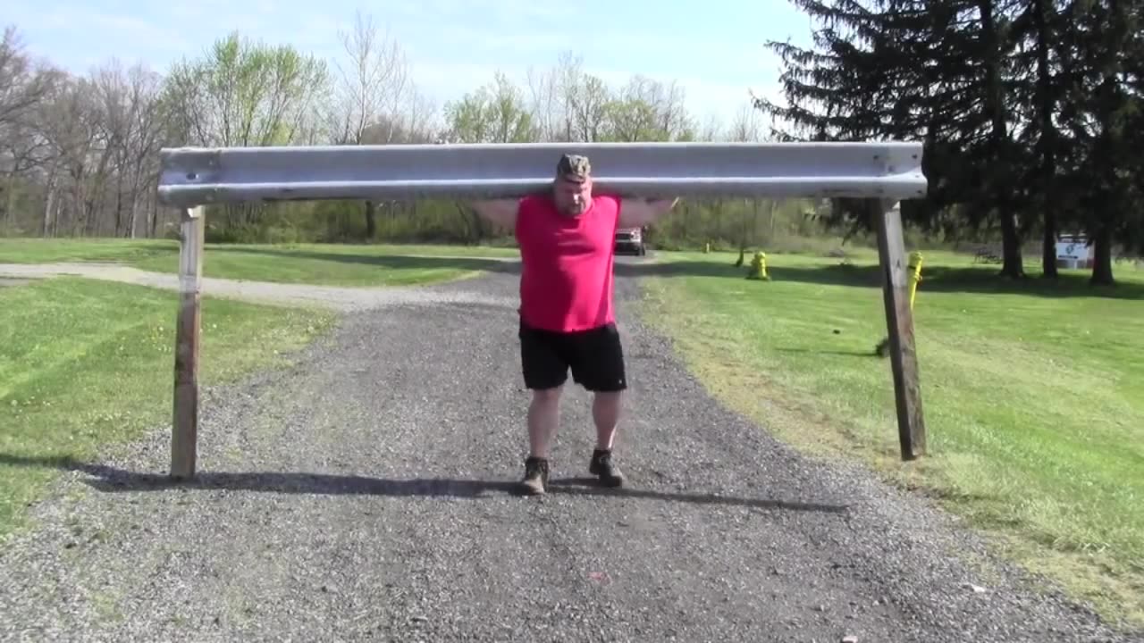 Strongman Steve McGranahan carries heavy guardrail on his shoulders