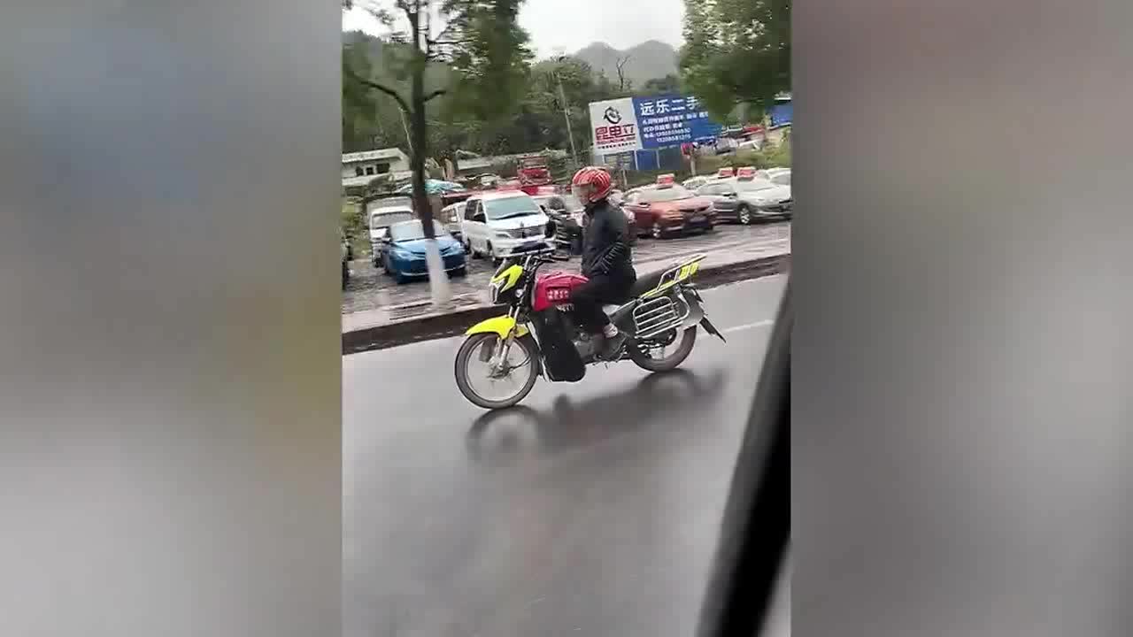 Chinese man casually rides motorcycle with both hands in his pockets