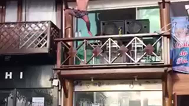 Music guy in bathing suit dances on balcony