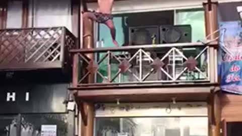 Music guy in bathing suit dances on balcony