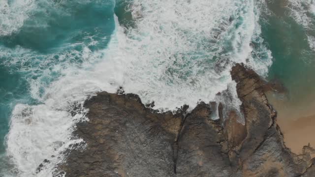 The waves slap mercilessly against the rocks!