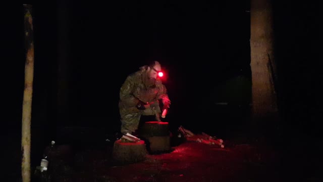 Battoning pine for kindling with an axe. At night. For a campfire