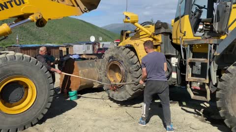 Guys Remove Bulldozer Tire