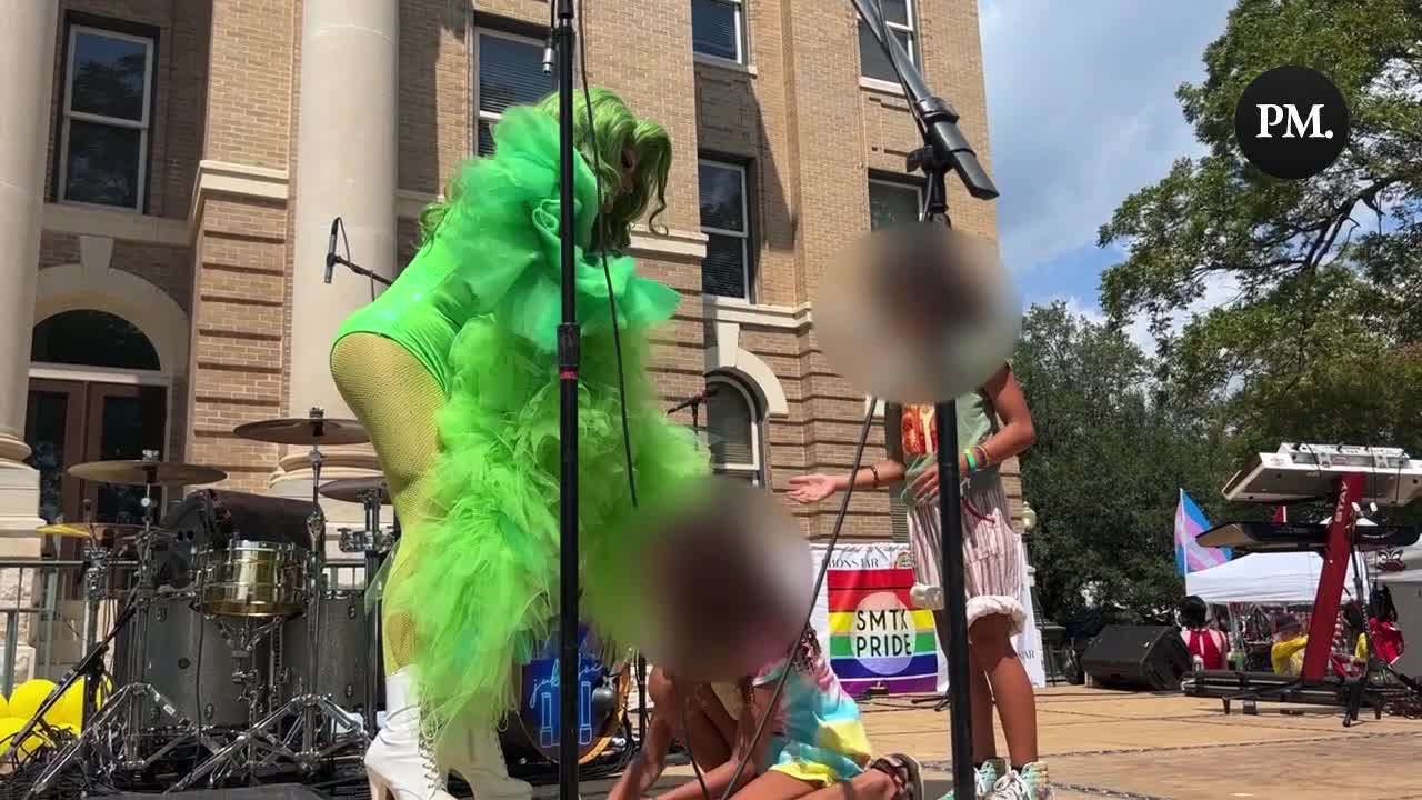 A drag queen invites children to help collect the money that is all over the stage