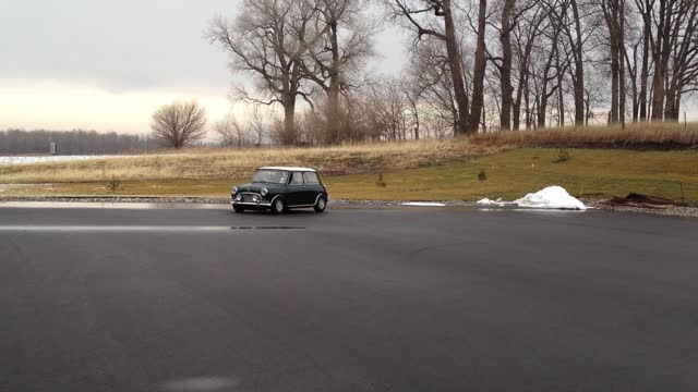 Serviceman Playing With Old Mini Cooper In Wet