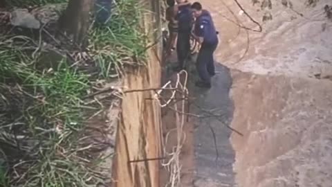 Brazilian military police officers saving a child during flooding in São Paulo