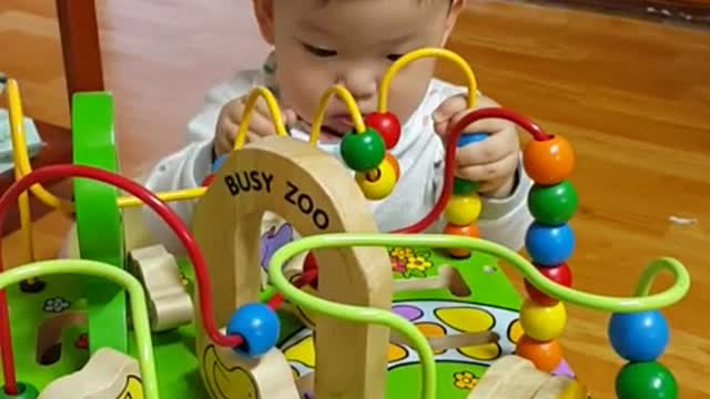 This is a video of a baby concentrating while playing with toys.