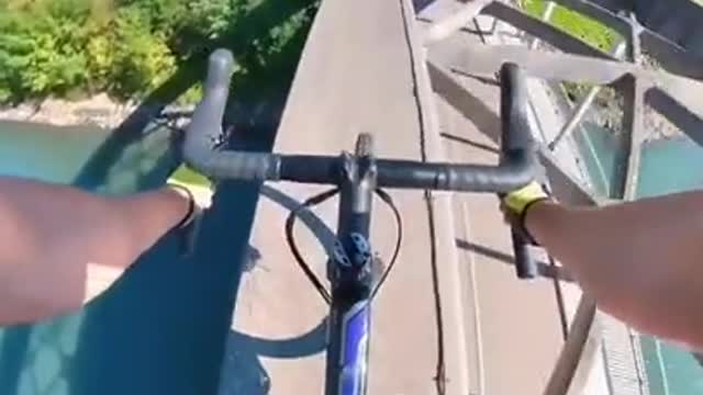 A biker crosses the bridge in his own way