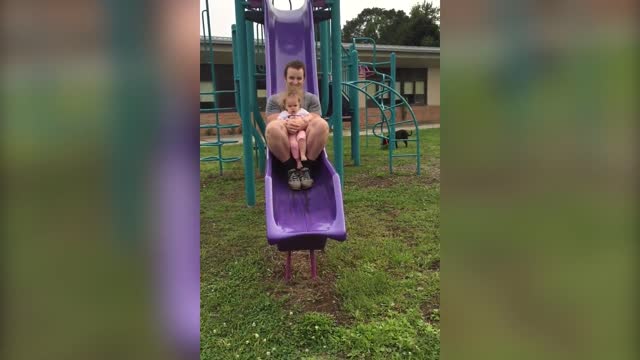 A Tot Girl Goes Down A Slide For The First Time