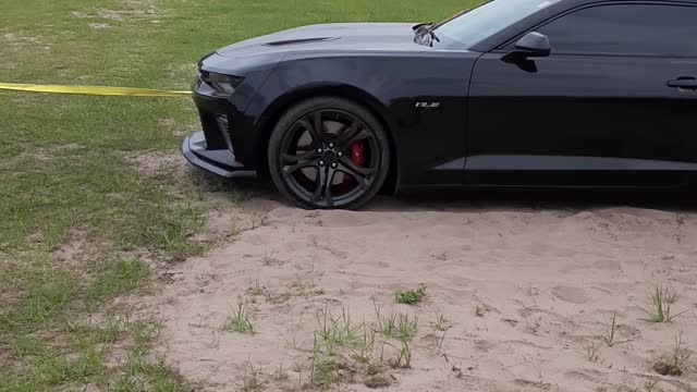 A Ford 150 coming to the rescue for a Camero stuck in the sand