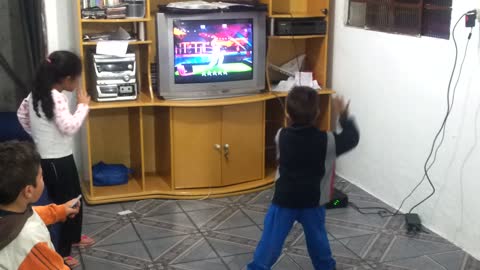 Adorable little boy dances to music with video game
