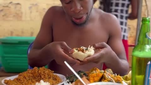 African man eating all manner of food at once