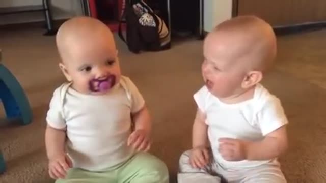 TRy not to laugh. Twin baby girls fight over pacifie