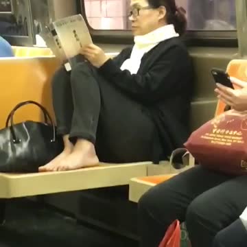 Woman takes shoes off bare feet on seats