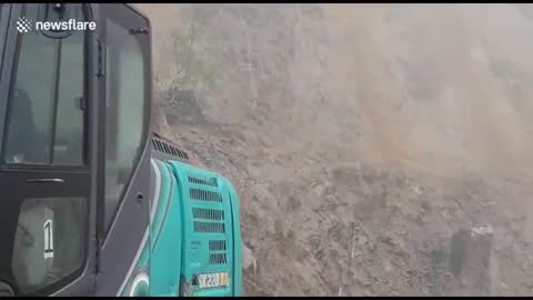 Workers move back moments before landslide crashes onto road in India