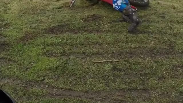 Bmx rider in blue falls off bike unto grass