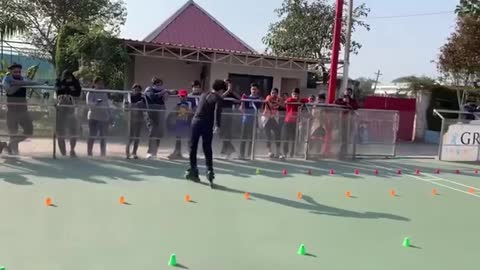 The boy adorably performs Roller Skating in a zigzag pattern across the hurdles on the stage.