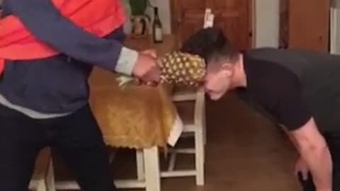 Guy hits friend across head with a pineapple