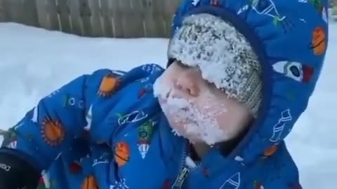 Watch how cute this child eats snow