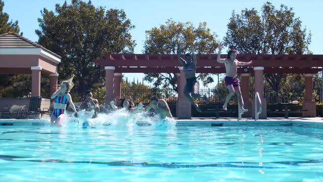 A group of friends jumping in a pool